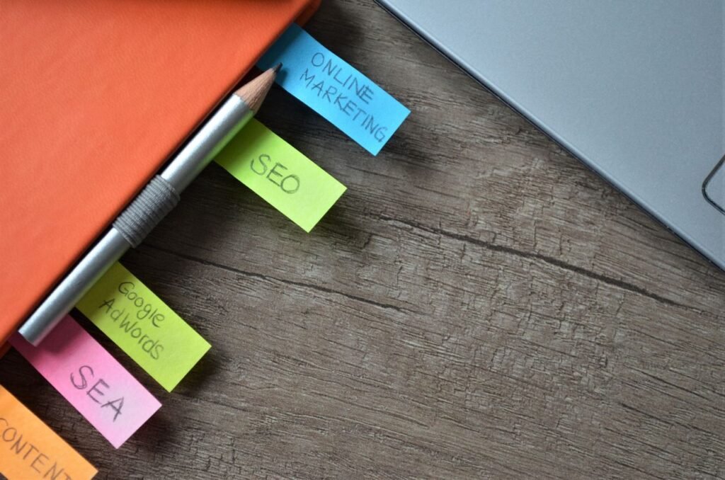 pexels-photo-927576-927576 Close-up of SEO strategy planner with colorful sticky notes and a pencil on a notebook.